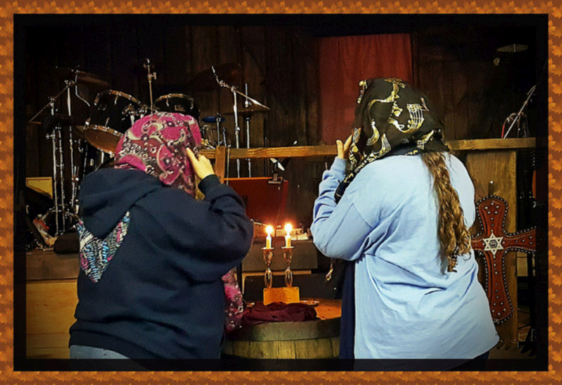 women praying at cowboy church on a friday