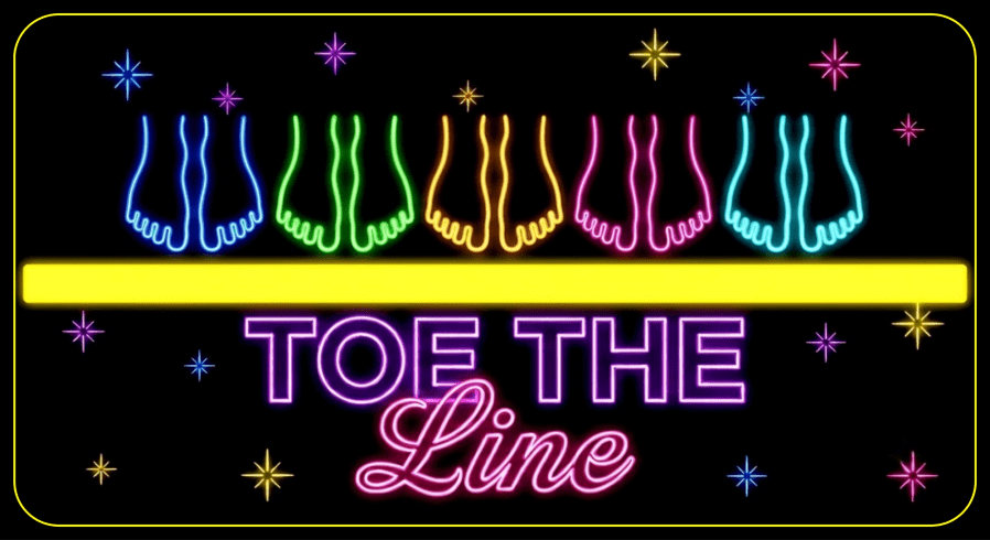 A vibrant neon sign on a black background featuring a row of five pairs of barefoot feet in bright neon blue, green, orange, pink, and cyan. The feet are positioned neatly above a thick, solid horizontal glowing yellow line without touching or crossing it. Below the yellow line, the title "TOE THE LINE" is written in purple block text stacked above pink script, surrounded by small multi-colored glowing starburst sparkles.