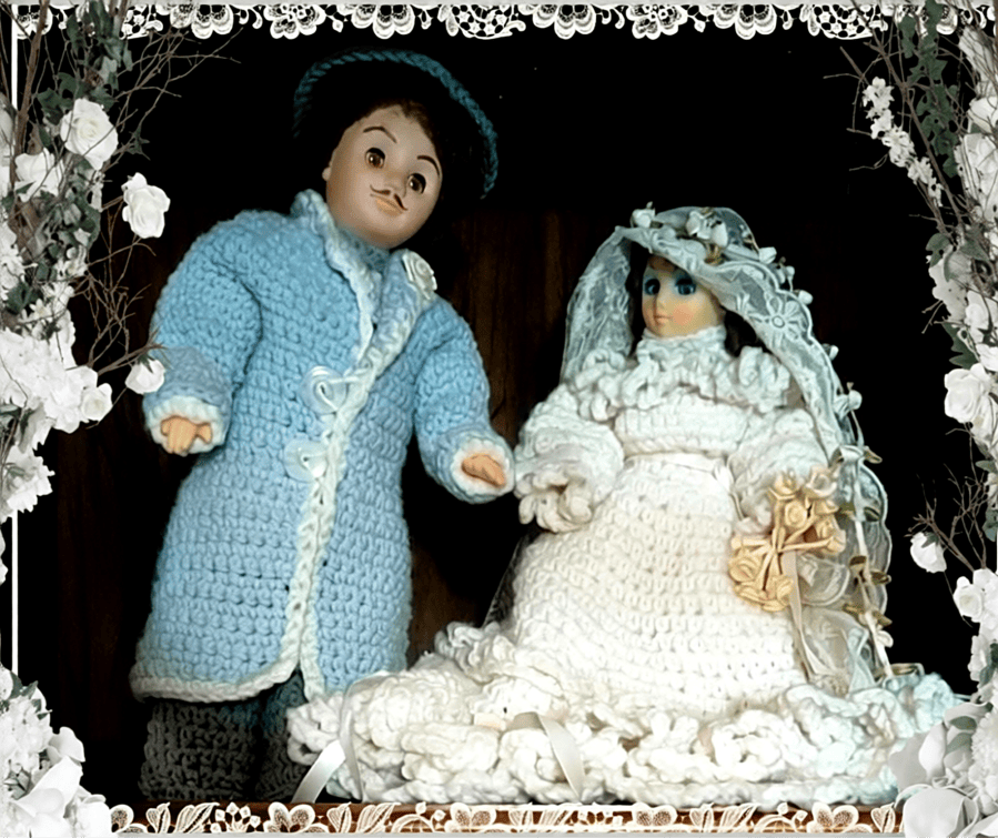 A crocheted groom and bride doll stand side by side on display on the top shelf of a wooden hutch. The image is framed with white decor of lace and flowers from the Photo Studio Pro app to give it an extra wedding look. This one is copyrighted by me (Crystal A Murray) because of the sentimental value. 